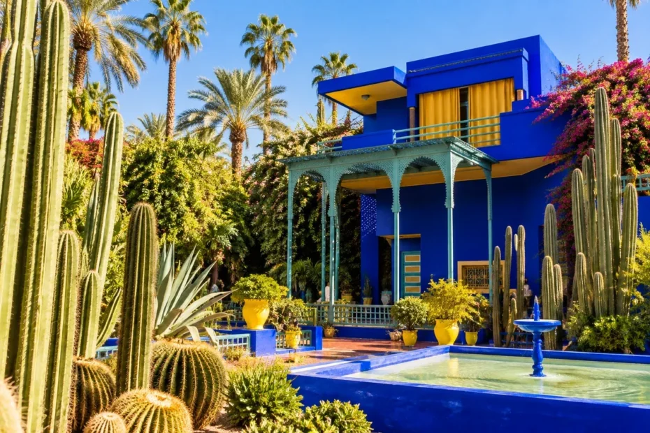Jardim Majorelle em Marrakech, com construção azul-cobalto entre palmeiras e cactos; ilustração editorial realista